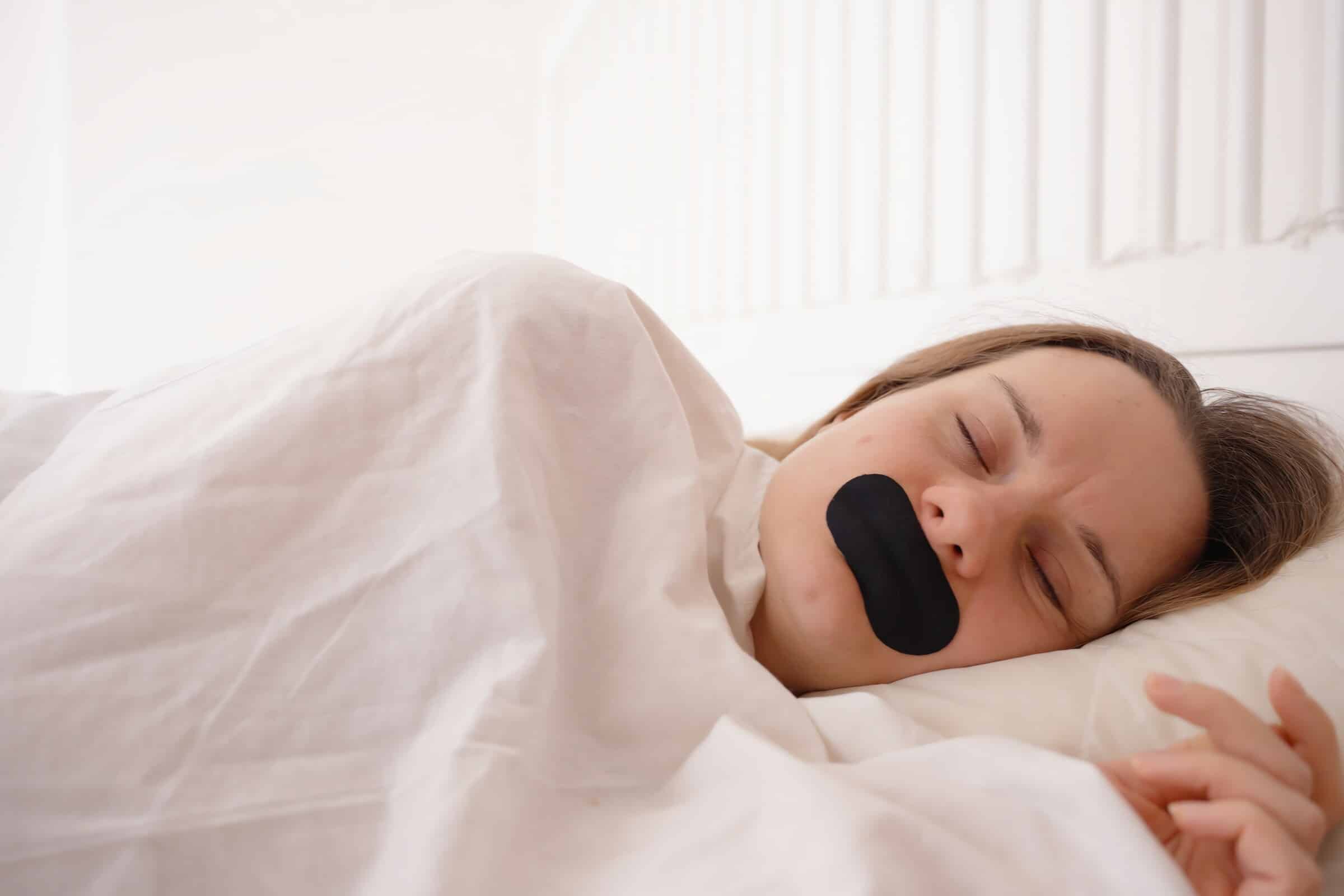 Frau schläft mit Mundpflaster – Mouth Taping als Teil des Morning-Shed-Rituals