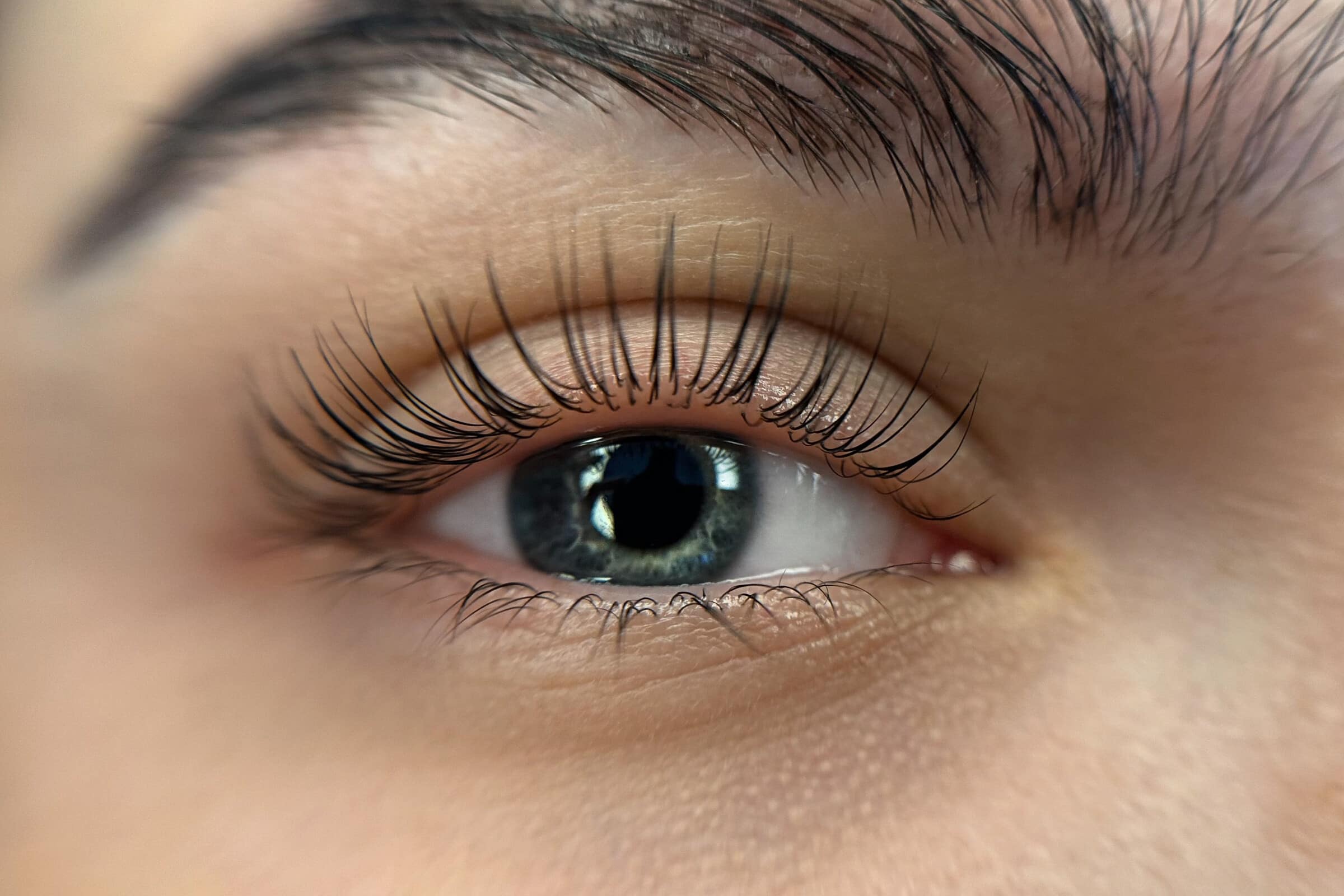 Auge mit geschwungenen Naturwimpern nach einem Wimpernlifting