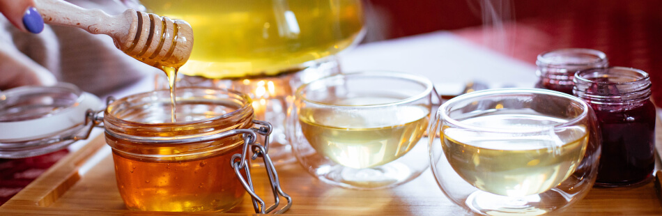 Tees und Honid können bei Halsschmerzen sehr wohltuend sein.